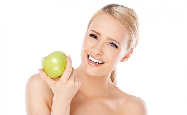 Adorable and healthy woman holding apple